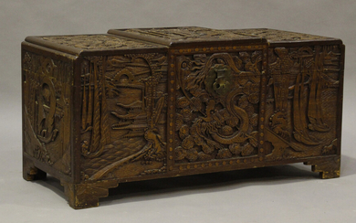 An early 20th century Chinese camphor trunk, carved in high relief with dragons and landscapes, heig