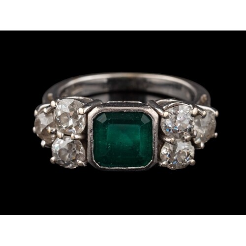 An emerald and diamond ring: the square cut emerald, in a co...
