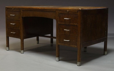 An oak desk, c.1930, the rounded rectangular top above an...
