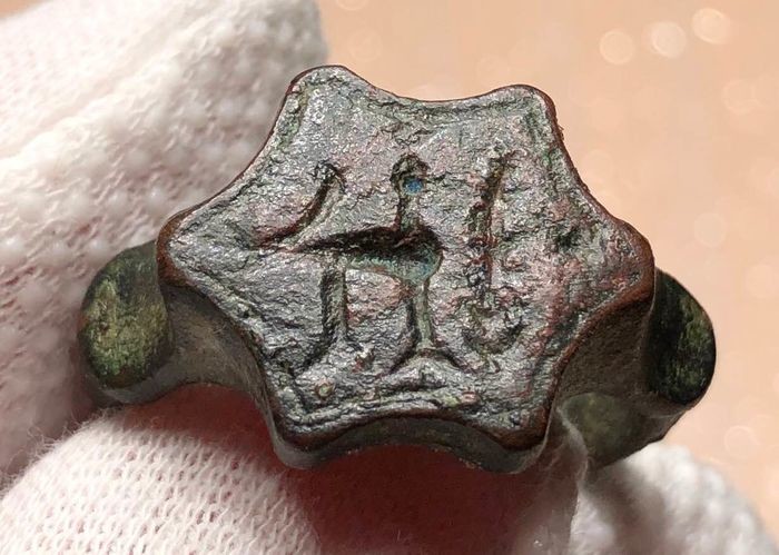 Ancient Roman Bronze Ring with an Exceptionally shaped Bezel engraved with a two Roosters and a Palm Branch.