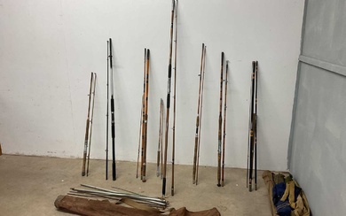 A collection of 8 fishing rods, some with canvas cases,...