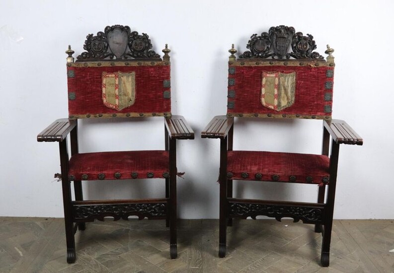 Pair of armchairs in molded and carved wood, brass and brass repoussé, velvet embroidered with wire coat of arms and copper applications.