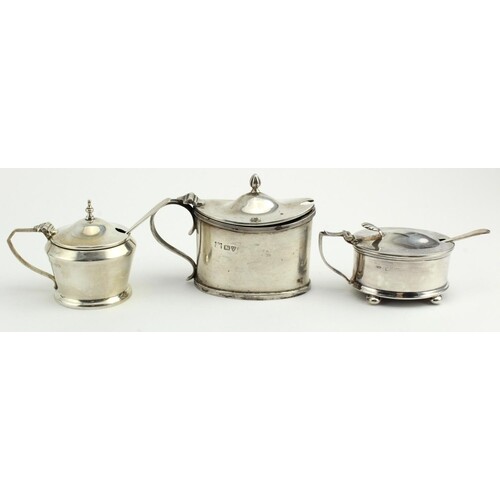 Three silver mustard pots and two silver spoons. Two pots ar...