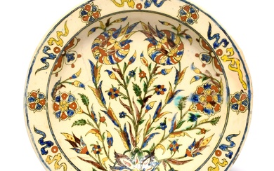 Un plat de style Iznik de Kutahya, fin du 18e/19e siècle, audacieusement peint d'un arrangement...