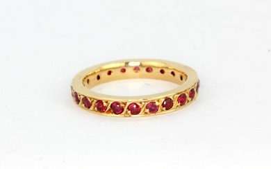 A 14ct yellow gold (worn stamp 585) ruby set full eternity ring, (K).