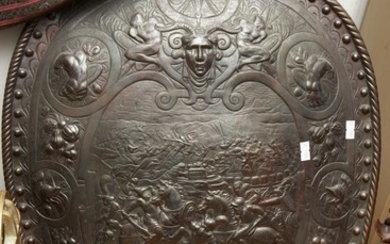 A CLASSICAL STYLE CAST IRON SHIELD, WITH A CENTRAL BATTLE SCENE HEIGHT 64CM