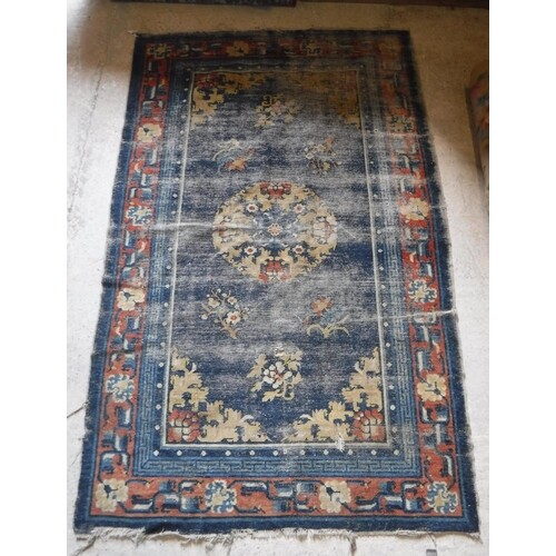 A Chinese rug, the central panel set with circular floral de...