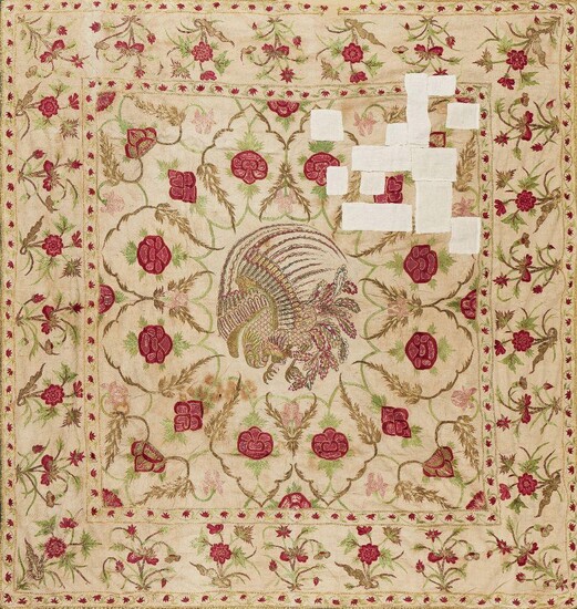 A Mughal embroidered floor spread, India, 18th century, for the European market, the cotton ground quilted and embroidered in silk and metal thread with a border of flowers, the field with a central, Chinese-style phoenix, 144 x 158cms. Provenance:...