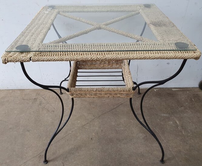 A WROUGHT IRON AND WOVEN SEAGRASS OUTDOOR TABLE