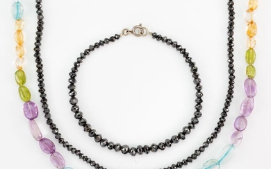 A black diamond necklace and bracelet and multi-gem bead necklace, the black diamond necklace and bracelet composed of facetted black diamond beads, length 45cm and 18cm respectively, and a tumbled bead necklace composed of amethyst, citrine...