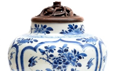 A blue and white vase with wooden lid