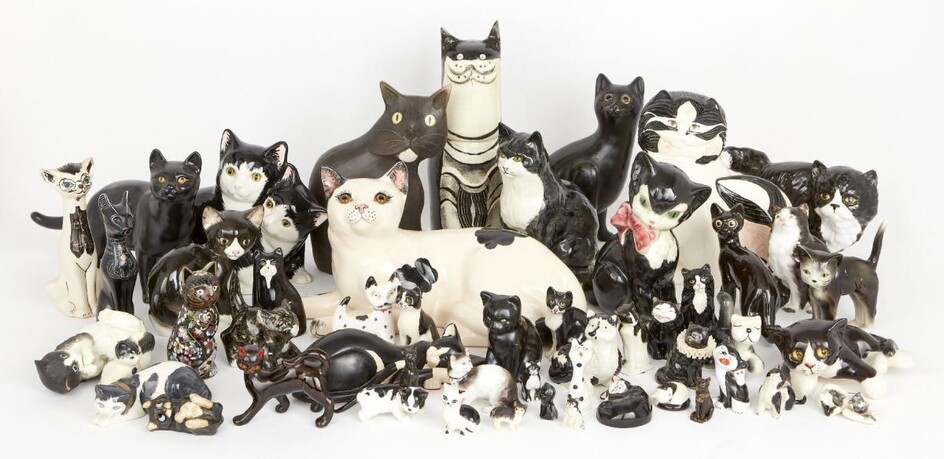 A collection of black and white pottery cats, including; examples of factory made, studio pottery and cloisonné with examples from Royal Doulton, Royal Worcester, Staffordshire, Raymond Potteries, Goebel and others, tallest 30.5cm (lot)