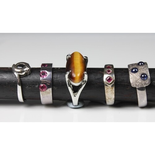 A collection of five silver rings set with various gemstones...