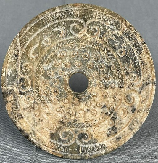 A disk made of stone. Probably Jade, China, Bi Disc