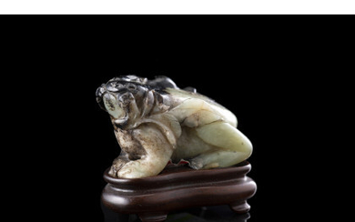 A green and russet jade carving of a beast, on wood base China, 20th century (h. 5.5 cm.)