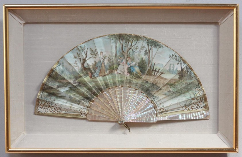 A hand-painted, mother of pearl fan, painted with a scene of...