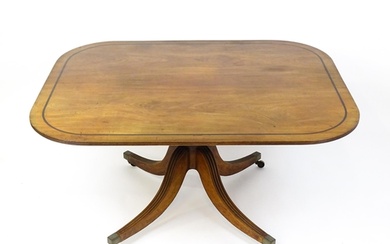 A late Georgian mahogany tilt top dining table with a ebonis...
