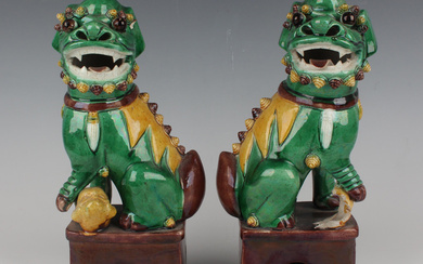 A pair of Chinese famille verte enamelled biscuit porcelain figures of Buddhistic lions, each green