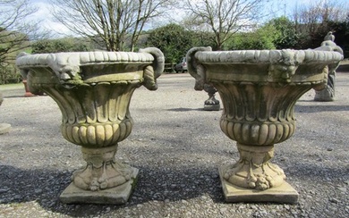A pair of large weathered cast composition stone garden urns...