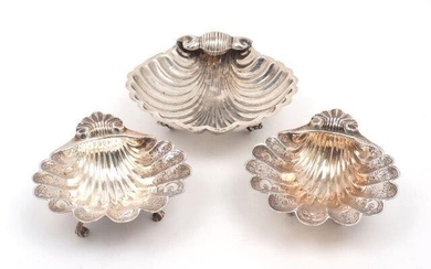 A pair of silver scallop shell dishes, Birmingham, 1968, A Marston & Co., raised on three scroll feet and chased with foliate scroll decoration, 11.1 x 13.5cm together with a larger scallop shell dish, stamped 925, approx. 15cm dia., total weight...