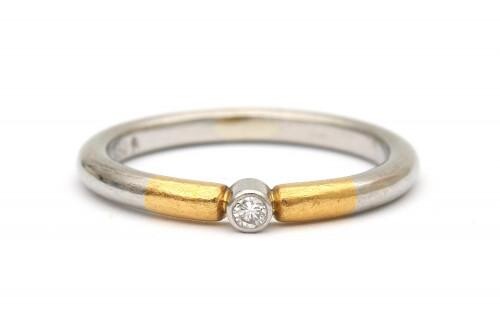 A platinum and gold diamond solitaire ring. Featuring a round platinum shank and yellow gold shoulders, set with a brilliant cut diamond of ca. 0.03 ct., ca. G-H, ca. VS. Platinum fineness: 950/1000. Gross weight: 3.4 g.