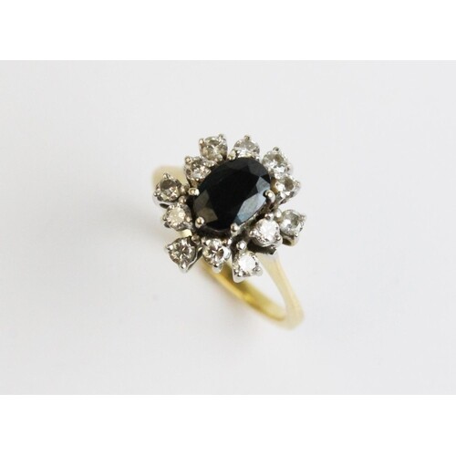 A sapphire and diamond cluster ring, comprising a central ov...