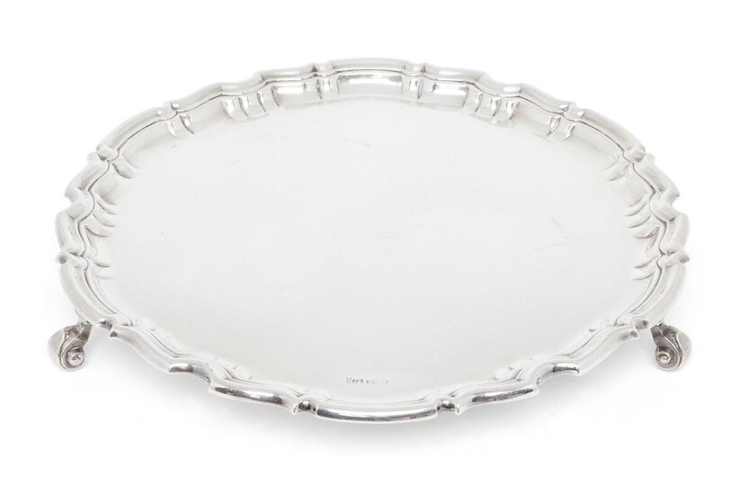 A silver salver with pie crust border, Sheffield, 1912, Joseph Rodgers & Sons, stamped with star and cross trade mark, the salver raised on three scroll feet, 40.5cm dia., approx. weight 57.4oz