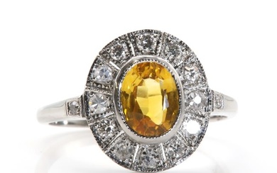 A yellow sapphire and diamond oval cluster ring