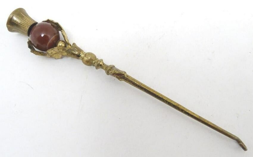 An early 20thC gilt metal button hook with an ornate