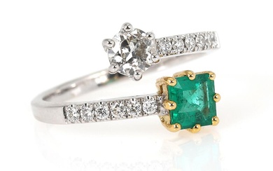 An emerald and diamond ring set with a square-cut emerald weighing app....