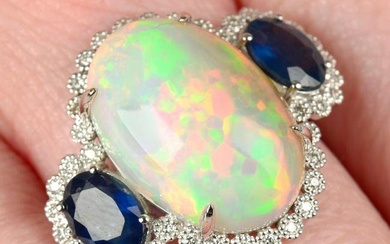 An opal and sapphire three-stone ring, with brilliant-cut diamond surround.Opal weight 8.26cts