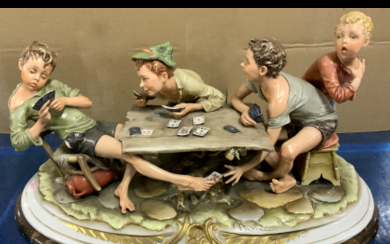 Bruno Merli "I bari" gruppo in porcellana decorato in policromia (cm 50x25) Poggiante su base in legno (difetti)
