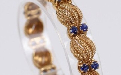 CARTIER Paris, Gold bracelet (750) with twisted gadrooned decoration and alternation of 24 small sapphires. D : 6 cm, Weight : 37.8 gr.