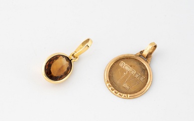 Deux petites breloques en or jaune (750) : - une médaille ronde gravée de caractères...