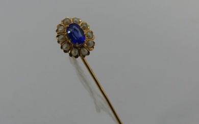 Epingle de cravate en or sertie dans un ovale de perles et d'une pierre bleue...