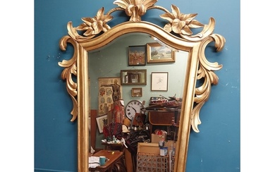 Gilt wall mirror mounted in a shield shaped frame surmounted...