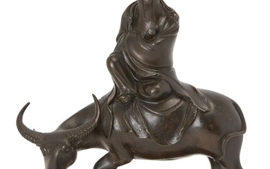 Property of a Gentleman (Lots 55-80) A Chinese bronze figure of a sage riding an ox, Ming dynasty, 17th century, modelled seated atop the ox clutching a scroll, fitted wood stand, 26cm high 明 十七世紀 壽老騎牛銅像 來源：紳士私人收藏