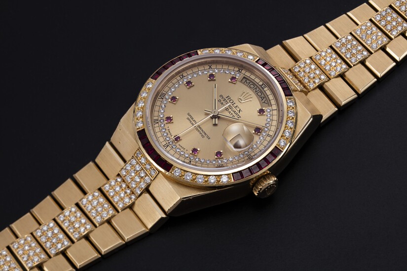 ROLEX, A GOLD OYSTERQUARTZ DAY-DATE WITH A DIAMOND AND RUBY-SET BEZEL AND INTEGRATED GOLD ‘KARAT’ BRACELET, REF. 19188