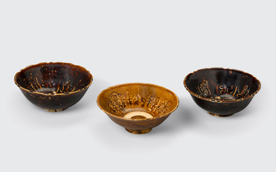 A group of three brown glazed bowls with impressed decoration
