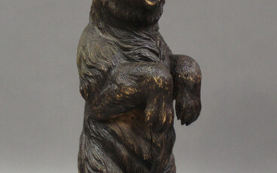 A 19th century Swiss Black Forest carved softwood stand, modelled in the form of a bear with inset g