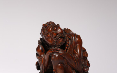 A CHINESE CARVED HARDWOOD FIGURE OF A LUOHAN