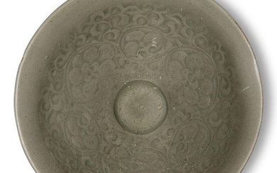 A Chinese Yaozhou celadon moulded 'peony' bowl, Song dynasty, on short foot with slightly curved sides that rise to an everted rim, the interior carved with peony blossoms issuing from a dense pattern of leafy stems, covered in an allover olive...