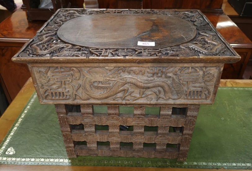 A Chinese wooden scholar's desk ornately carved with dragons...