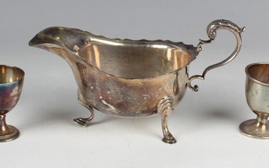 A George VI silver sauceboat with foliate capped scroll handle, on scroll legs terminating in hoof f