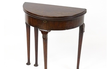 A Georgian mahogany demi lune card table / games table with ...