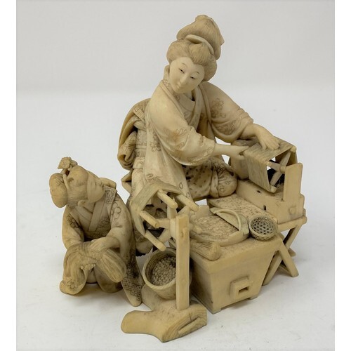 A Japanese carved ivory group, of a lady spinning, with an a...