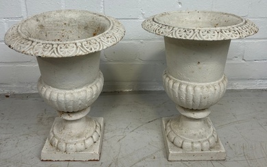 A PAIR OF WHITE PAINTED CAST IRON GARDEN URNS,...