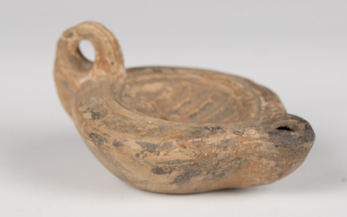 A Roman terracotta oil lamp, the central well decorated with a palmette, length 8.5cm.