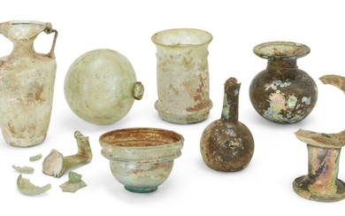 A collection of Roman glass vessels Circa 1st-4th Century A.D., including a small Roman bowl with collar rim on a pad base, 4.2cm high; a cylindrical beaker with pronounced rib below the rim and above the base, 9.9cm high; a spherical bottle with...