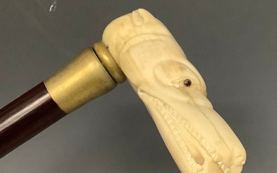 A contemporary carved bone handled walking stick, the handle...